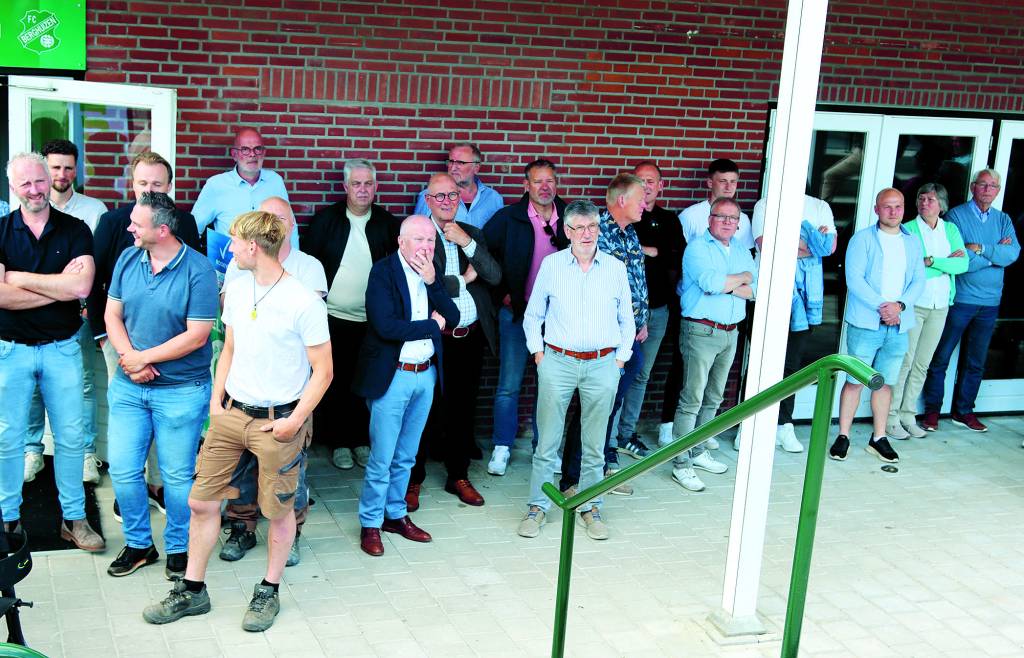 Vele genodigden slaan de officiële openingshandeling gade.